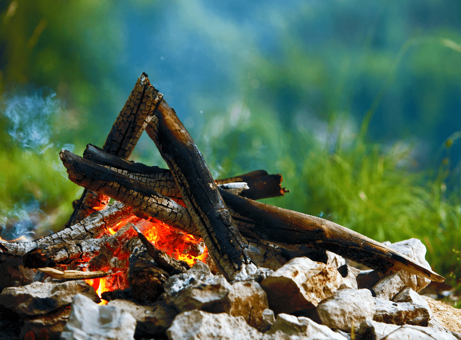 stacked firewood burning in a campfire