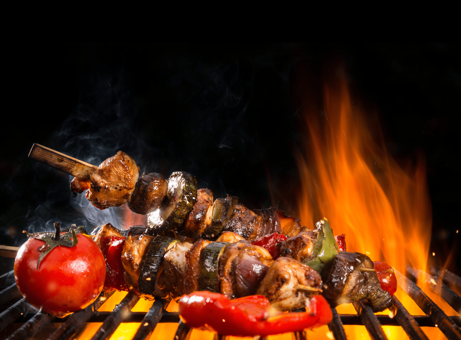 Beef kabobs grilling on bbq with tomato